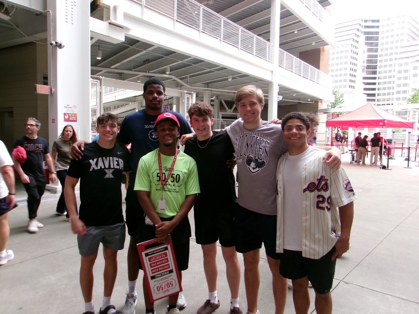 Yohan in a Reds 50/50 raffle shirt on the concourse at Great American Ball Park with a group of fans